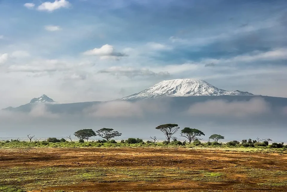 Snow-capped Kilimanjaro rising above the Amboseli savanna with elephants in the foreground