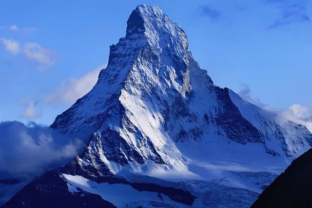 The Matterhorn's iconic crooked pyramid peak above the forested Zermatt valley