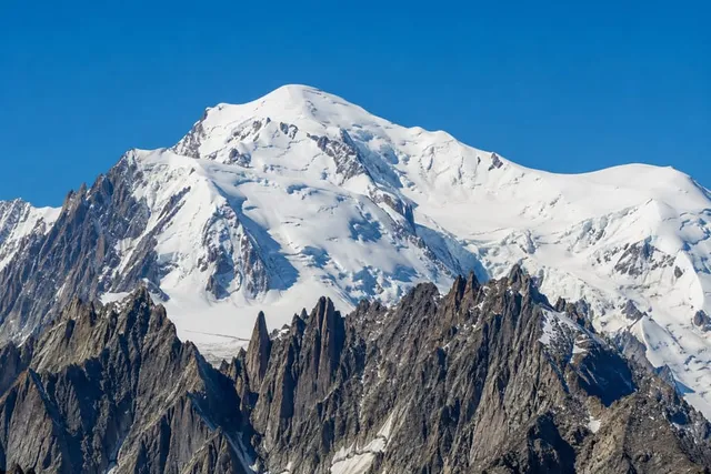 Mont Blanc's broad glaciated snow dome above the rocky aiguilles near Chamonix
