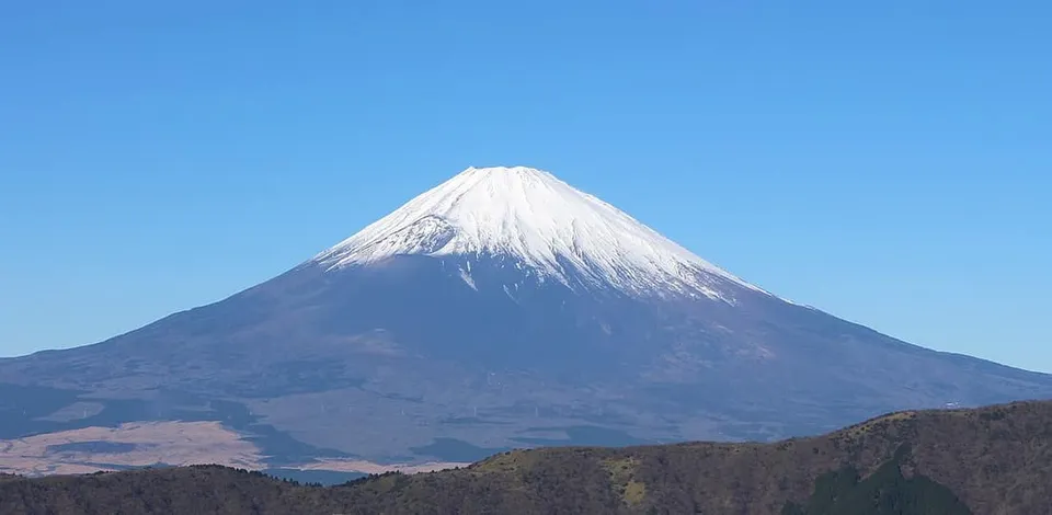 Snow-capped symmetric cone of Mount Fuji viewed from Ōwakudani